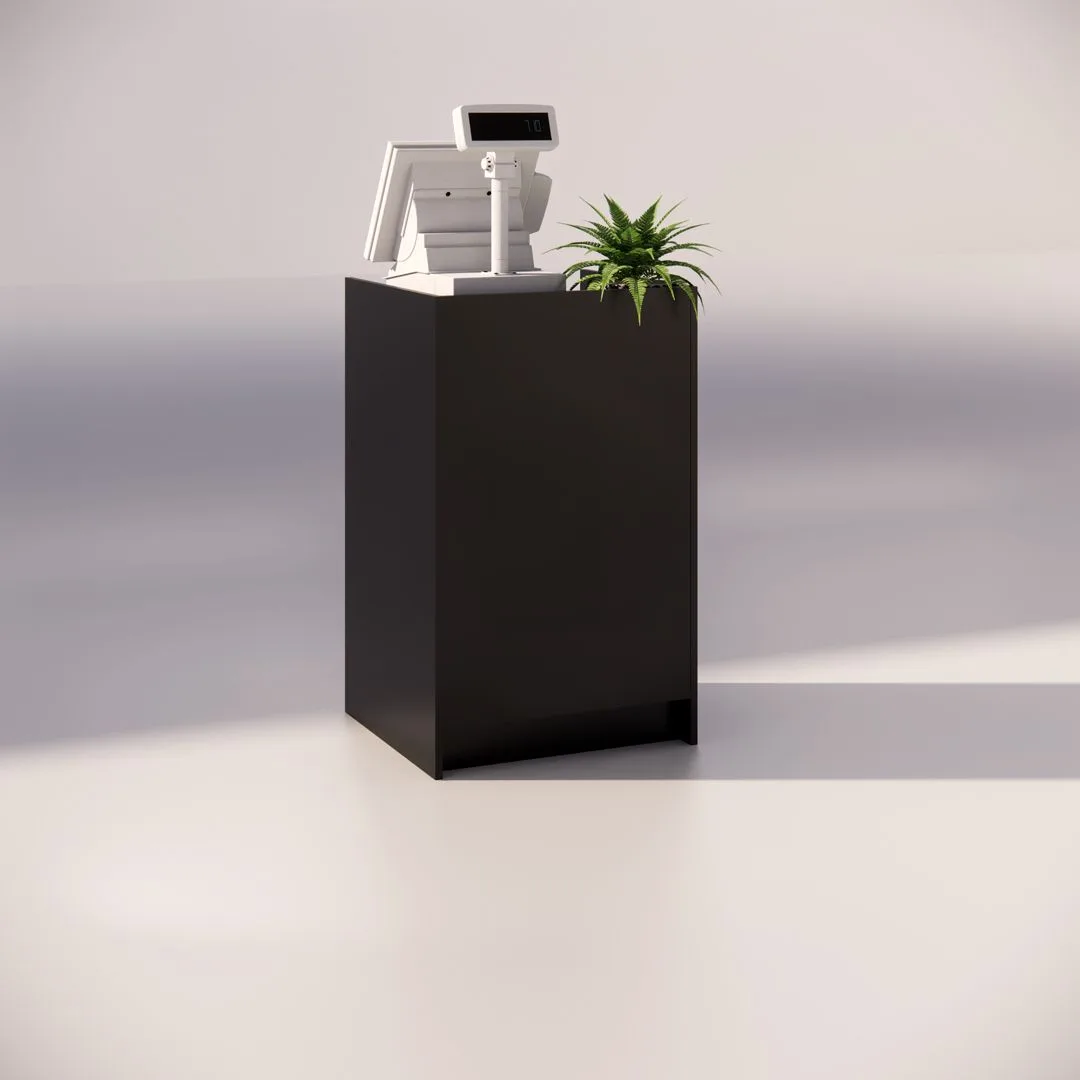 A minimalist black pedestal with a white cash register on top. A small green plant is placed beside the register, casting soft shadows on the smooth, light gray surface.