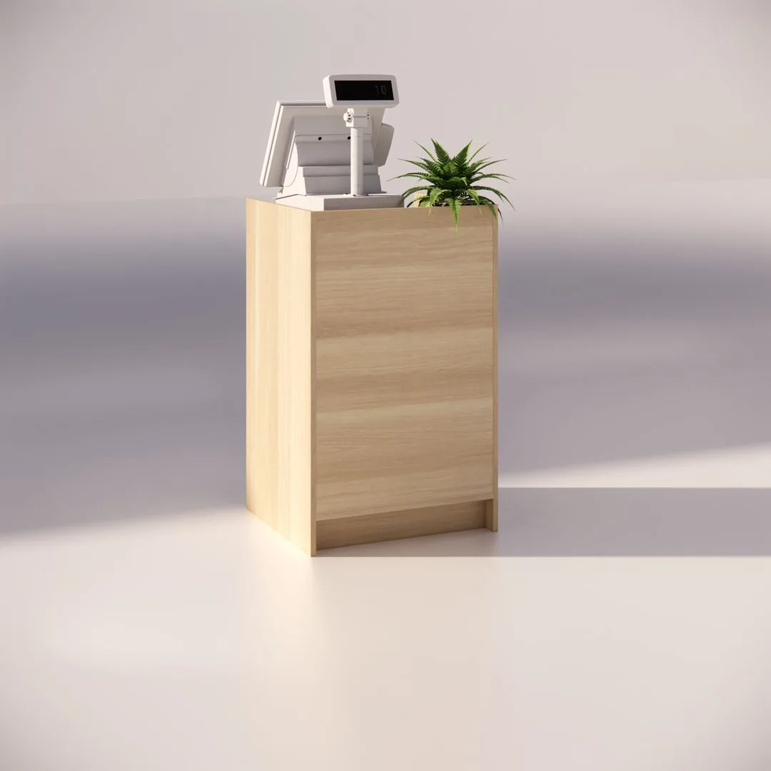 A light wooden podium with a cash register and a small green plant on top. The background is plain and softly lit, highlighting the minimalist setup.